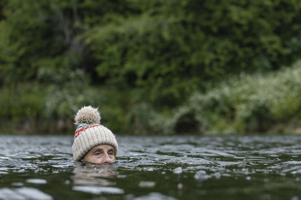 A person with Dementia in lake wearing a wooly hat - most wandering seniors head for water.