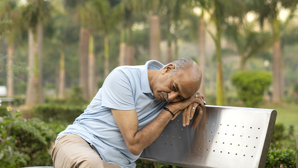 Senior on a park bench looking despondent as if they may be lost.